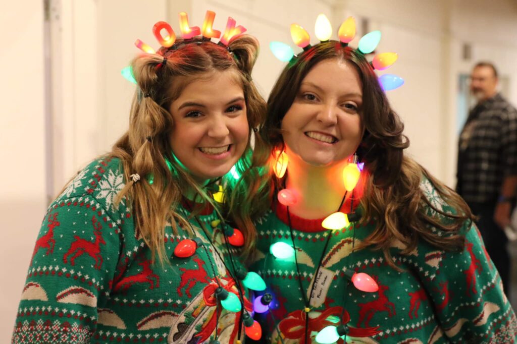 Leaders dressed in festive Christmas outfits. This image serves as the header image for our blog, 25 Christmas Ideas for Your Family Ministry