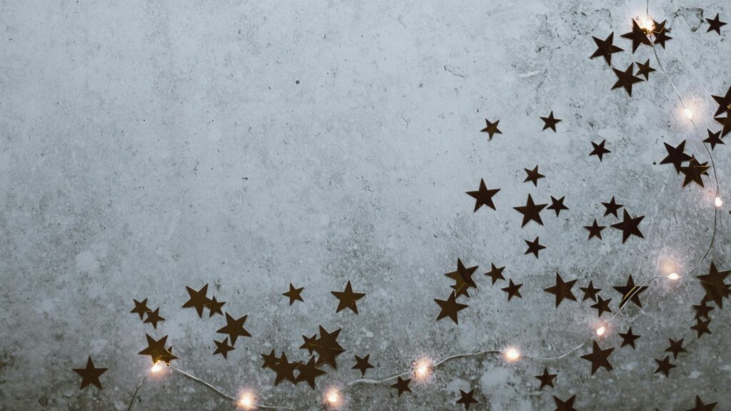 Star confetti and Christmase lights. This image is used for the 5 Do’s and Don’ts for Church Communications During the Holidays blog.