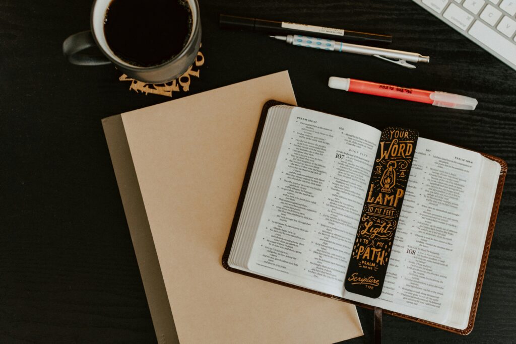 A bible with a cup of coffee and pens and journal. Image is used as the header for the blog Faith at Their Fingertips: Helping Students Use YouVersion to Build Everyday Faith.